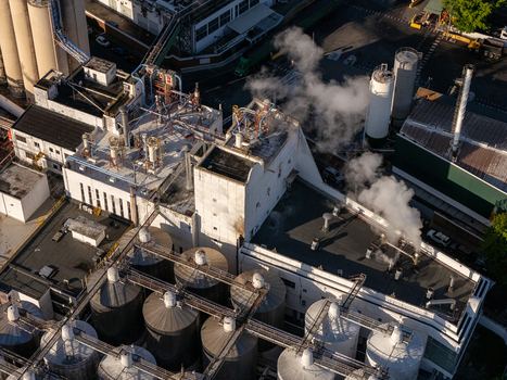 Aerial view of the beer industrial complex featuring large metal silos industrial buildings with steam rising from vents and complex piping systems in Santo Domingo Dominican Republic. Aerial view of the beer industrial complex featuring large metal silos industrial buildings with steam rising from vents and complex piping systems in Santo Domingo Dominican Republic.
