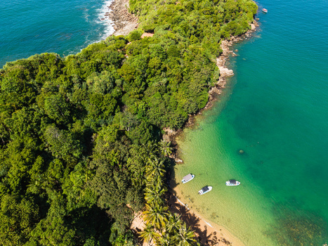 Aerial view of Jungle Beach with turquoise waters lush tropical forest and small boats anchored near the shore Unawatuna Sri Lanka. Aerial view of Jungle Beach with turquoise waters lush tropical forest and small boats anchored near the shore Unawatuna Sri Lanka.