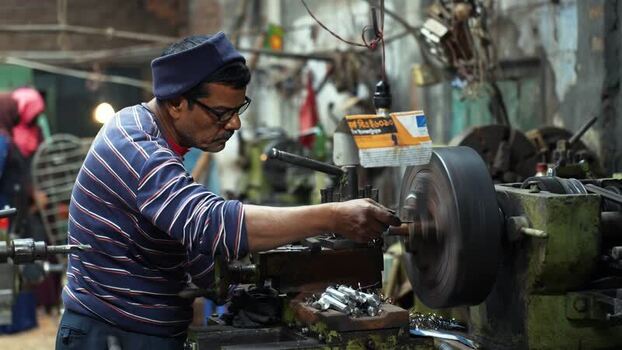 View of a worker operating a lathe machine in Kushtia Bangladesh.
