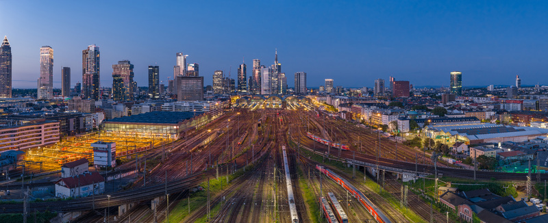 Aerial view of the Hauptbahnhof railway tracks and the illuminated skyscraper skyline during twilight in Frankfurt am Main Hessen Germany.