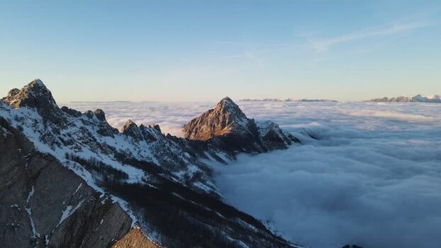 Aerial view of Pizzo d Uccello peak above clouds Italy.