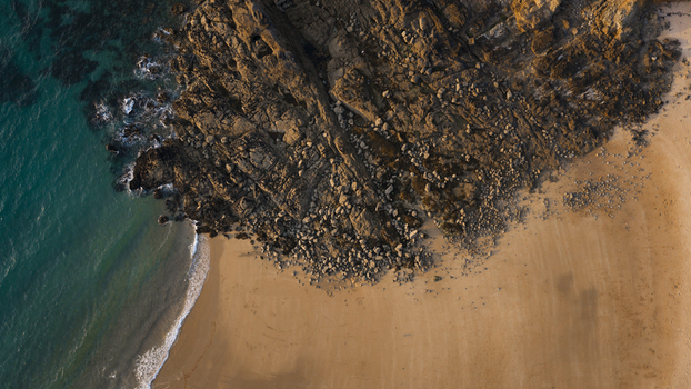 Aerial view of the rugged coastline at Cap Frehel featuring rocky cliffs sandy beach and turquoise ocean waters in Plevenon Brittany France. Aerial view of the rugged coastline at Cap Frehel featuring rocky cliffs sandy beach and turquoise ocean waters in Plevenon Brittany France.