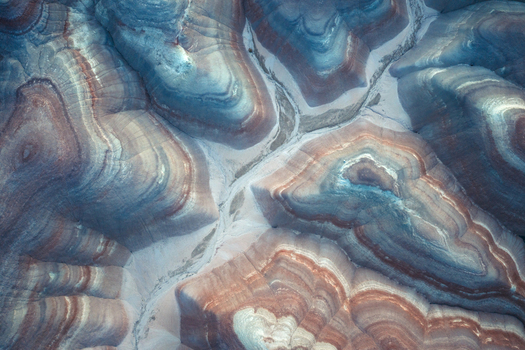Aerial view of layered earth tones intertwine like brushstrokes on a canvas creating a mesmerizing geological masterpiece Hanksville Utah United States. Aerial view of layered earth tones intertwine like brushstrokes on a canvas creating a mesmerizing geological masterpiece Hanksville Utah United States.