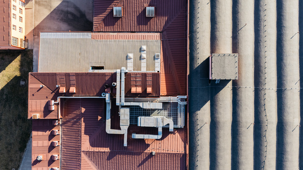 Aerial view of industrial building rooftops featuring complex ventilation systems and corrugated metal surfaces in Sremska Mitrovica Vojvodina Serbia. Aerial view of industrial building rooftops featuring complex ventilation systems and corrugated metal surfaces in Sremska Mitrovica Vojvodina Serbia.