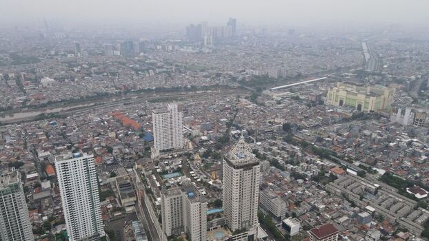 Aerial view of the dense urban landscape of Jakarta Pusat with high rise buildings and residential rooftops in Kecamatan Menteng Daerah Khusus Ibukota Indonesia. Aerial view of the dense urban landscape of Jakarta Pusat with high rise buildings and residential rooftops in Kecamatan Menteng Daerah Khusus Ibukota Indonesia.