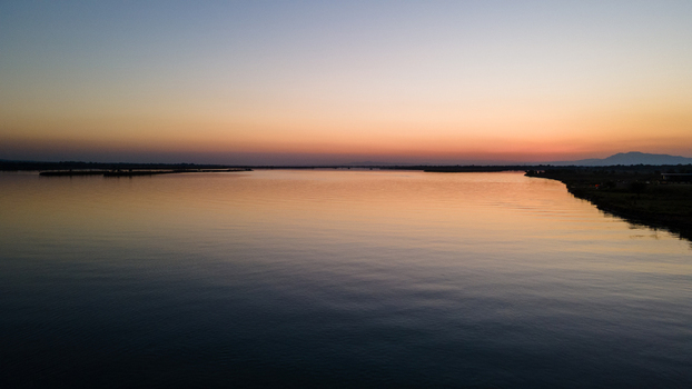 Aerial view of Jhelum City and the Jhelum River at sunset with calm water reflecting the orange sky Jhelum Punjab Pakistan. Aerial view of Jhelum City and the Jhelum River at sunset with calm water reflecting the orange sky Jhelum Punjab Pakistan.
