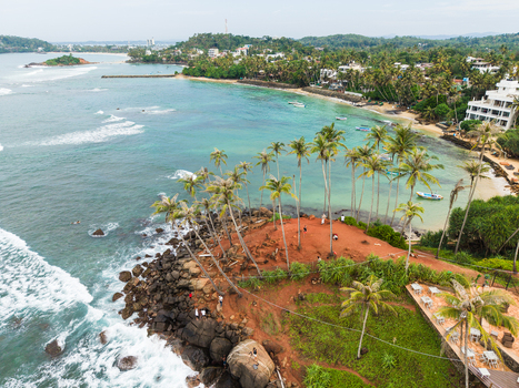 Aerial view of Coconut Tree Hill with its iconic palm trees overlooking the turquoise ocean and rocky coastline in Mirissa Southern Province Sri Lanka. Aerial view of Coconut Tree Hill with its iconic palm trees overlooking the turquoise ocean and rocky coastline in Mirissa Southern Province Sri Lanka.