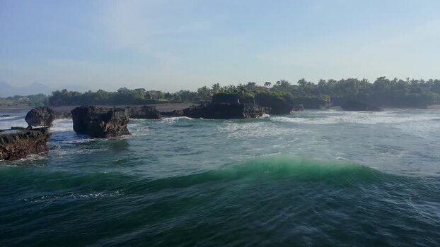 Aerial view of waves crashing against volcanic rocks on the coast Indonesia. Aerial view of waves crashing against volcanic rocks on the coast Indonesia.