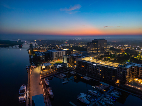 Aerial view of Riverfront Park at dusk featuring the Cape Fear River moored yachts modern buildings and the bridge in Wilmington North Carolina United States.