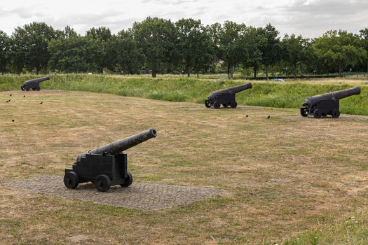 View of historic iron cannons positioned on the grassy ramparts of the old fortification in Heusden North Brabant Netherlands.