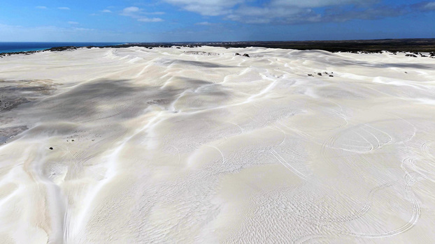 Aerial view of Lancelin Sand Dunes with vast white sand formations tire tracks from off road vehicles and the Indian Ocean in the distance Lancelin Western Australia Australia. Aerial view of Lancelin Sand Dunes with vast white sand formations tire tracks from off road vehicles and the Indian Ocean in the distance Lancelin Western Australia Australia.