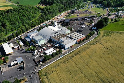 Geiselwind Germany 21 June 2025 Aerial view of Eventzentrum Strohofer Geiselwind musichall with outdoor stages crowds of people and surrounding green fields under a clear sky. Geiselwind Germany 21 June 2025 Aerial view of Eventzentrum Strohofer Geiselwind musichall with outdoor stages crowds of people and surrounding green fields under a clear sky.