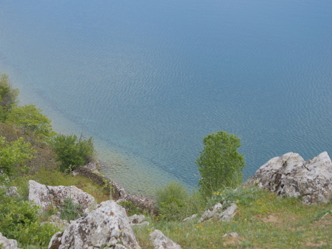 View of the rocky shoreline and clear blue waters of Lake Ohrid near the village of Lin Korce County Albania.