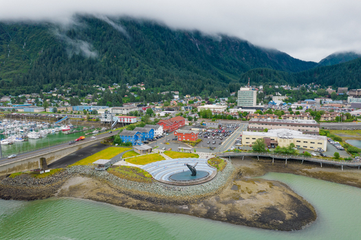 Aerial view of the breaching whale statue in the waterfront park with the harbor urban buildings and misty mountains in the background in Juneau Alaska United States. Aerial view of the breaching whale statue in the waterfront park with the harbor urban buildings and misty mountains in the background in Juneau Alaska United States.