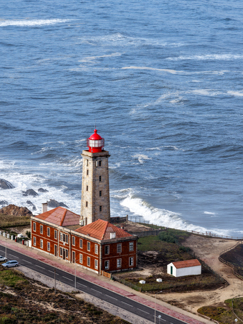 Aerial view of Farol Penedo da Saudade lighthouse with its stone tower and red lantern overlooking the Atlantic Ocean waves in Marinha Grande Leiria Portugal. Aerial view of Farol Penedo da Saudade lighthouse with its stone tower and red lantern overlooking the Atlantic Ocean waves in Marinha Grande Leiria Portugal.