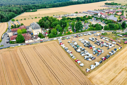 Aerial view of Schloss Jagersburg with its historic buildings a large parking area filled with vehicles and golden fields in Eggolsheim Bayern Germany. Aerial view of Schloss Jagersburg with its historic buildings a large parking area filled with vehicles and golden fields in Eggolsheim Bayern Germany.