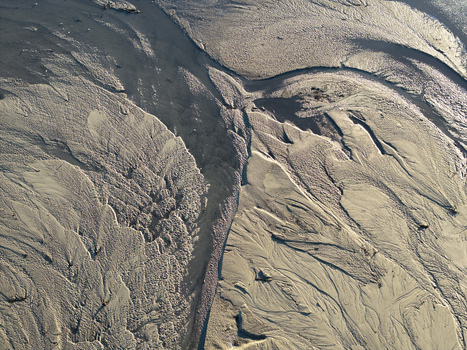 Aerial view of intricate sand patterns and water channels in a riverbed in Poland. Aerial view of intricate sand patterns and water channels in a riverbed in Poland.