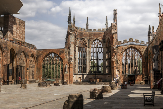 Coventry United Kingdom 20 July 2026 View of the historic ruins of Coventry Cathedral featuring weathered red sandstone walls Gothic window tracery and a paved courtyard.