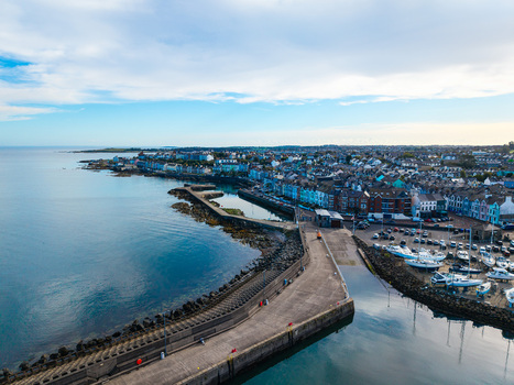 Aerial view of Bangor Harbour and Town with colorful buildings docked boats and a stone breakwater extending into the sea in Bangor Northern Ireland United Kingdom.