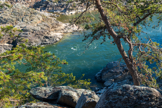 View of the river s turquoise waters swirl powerfully through the rocky gorge framed by the rugged textures of stone and the verdant foliage Great Falls Virginia United States. View of the river s turquoise waters swirl powerfully through the rocky gorge framed by the rugged textures of stone and the verdant foliage Great Falls Virginia United States.