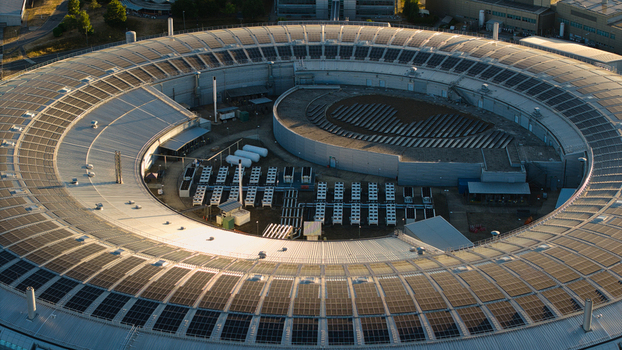 Aerial view of Diamond Light Source a circular synchrotron facility surrounded by greenery under golden hour light in Didcot United Kingdom.