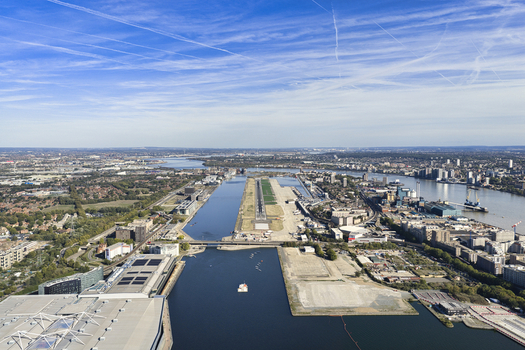 Aerial view of London City Airport with its runway extending between the River Thames and the surrounding urban landscape in London England United Kingdom. Aerial view of London City Airport with its runway extending between the River Thames and the surrounding urban landscape in London England United Kingdom.