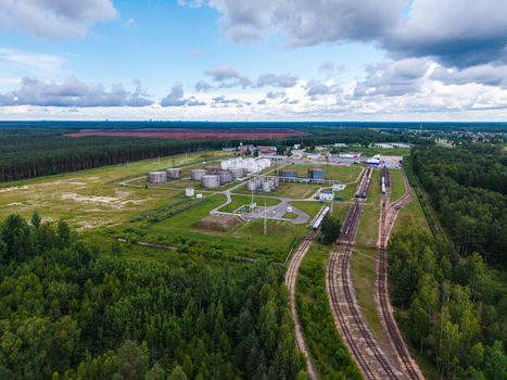 Olaine parish Latvia 04 July 2026 Aerial view of an industrial facility with storage tanks and railway tracks surrounded by dense forest under a cloudy sky. Olaine parish Latvia 04 July 2026 Aerial view of an industrial facility with storage tanks and railway tracks surrounded by dense forest under a cloudy sky.