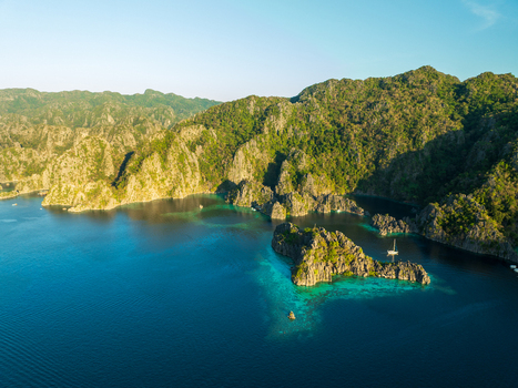 Aerial view of Twin Lagoon with turquoise waters surrounded by dramatic limestone cliffs and lush vegetation in Coron Mimaropa Philippines. Aerial view of Twin Lagoon with turquoise waters surrounded by dramatic limestone cliffs and lush vegetation in Coron Mimaropa Philippines.