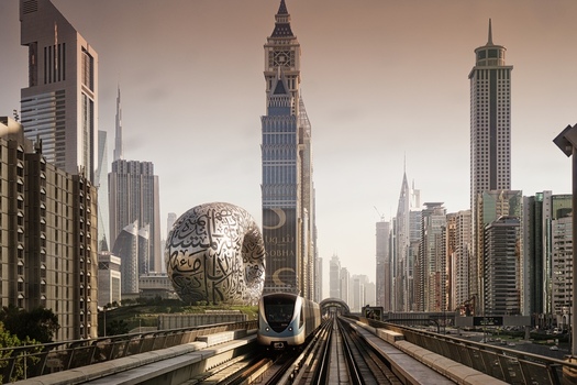Dubai United Arab Emirates 21 April 2023 View of the Museum of the Future and a Dubai Metro train traveling along the elevated tracks amidst the modern skyscrapers of the city skyline. Dubai United Arab Emirates 21 April 2023 View of the Museum of the Future and a Dubai Metro train traveling along the elevated tracks amidst the modern skyscrapers of the city skyline.