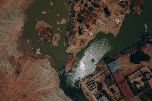 Aerial view of the landscape near Kano Madobi Kiru Road with green water bodies arid red soil and rural buildings in Watari Kano Nigeria. Aerial view of the landscape near Kano Madobi Kiru Road with green water bodies arid red soil and rural buildings in Watari Kano Nigeria.