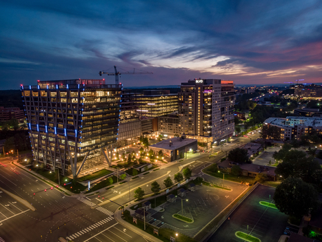 Reston United States 27 May 2020 Aerial view of modern office buildings and residential towers at twilight with illuminated windows and a construction crane. Reston United States 27 May 2020 Aerial view of modern office buildings and residential towers at twilight with illuminated windows and a construction crane.