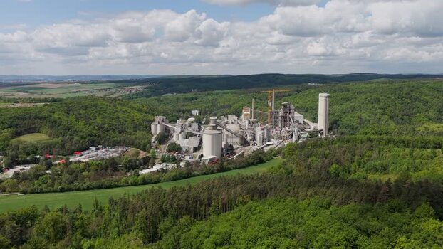 Aerial view of a cement plant in a lush forest Czechia.