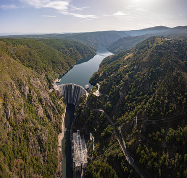 Aerial view of the Encoro de Santo Estevo dam spanning the Sil River canyon surrounded by steep forested slopes and lush greenery Ourense Ourense Spain. Aerial view of the Encoro de Santo Estevo dam spanning the Sil River canyon surrounded by steep forested slopes and lush greenery Ourense Ourense Spain.