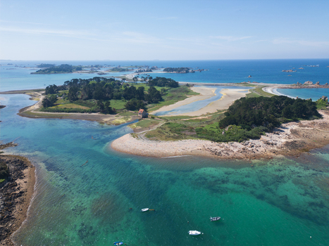 Aerial view of the turquoise waters and rocky islands of Plage de Port Blanc with small boats anchored near the shore in Penvenan Bretagne France. Aerial view of the turquoise waters and rocky islands of Plage de Port Blanc with small boats anchored near the shore in Penvenan Bretagne France.