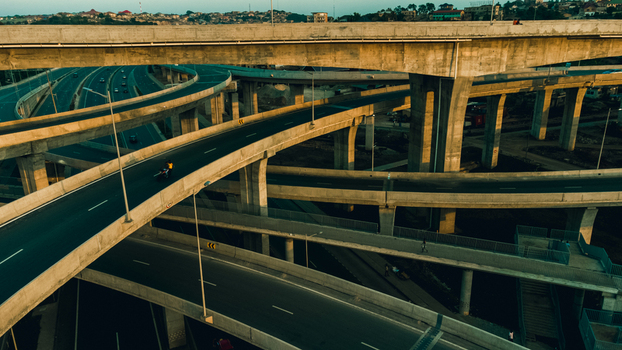 Aerial view of the multi level concrete structure of the Pokuase Interchange with traffic flowing on elevated roads during golden hour in Ga North Municipal Greater Accra Region Ghana. Aerial view of the multi level concrete structure of the Pokuase Interchange with traffic flowing on elevated roads during golden hour in Ga North Municipal Greater Accra Region Ghana.