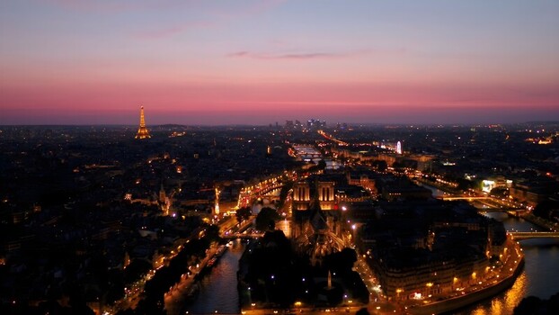 Aerial view of the Eiffel Tower and Notre Dame Cathedral illuminated at dusk along the Seine River in Paris Ile de France France. Aerial view of the Eiffel Tower and Notre Dame Cathedral illuminated at dusk along the Seine River in Paris Ile de France France.
