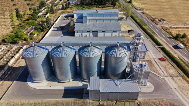 Aerial view of the storage silo Bavaniste facility featuring four large metal grain silos and a processing building surrounded by fields in Bavaniste Vojvodina Serbia.