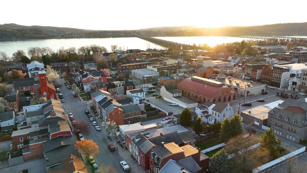 Aerial view of the historic town of Columbia at sunset featuring charming rooftops tree lined streets and a long bridge spanning the river in Columbia Pennsylvania United States. Aerial view of the historic town of Columbia at sunset featuring charming rooftops tree lined streets and a long bridge spanning the river in Columbia Pennsylvania United States.