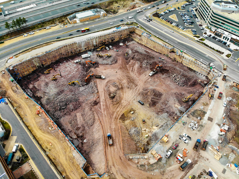 Reston Virginia United States 12 March 2019 Aerial view of a large construction site with heavy machinery and excavators working on an excavation pit near roads and buildings. Reston Virginia United States 12 March 2019 Aerial view of a large construction site with heavy machinery and excavators working on an excavation pit near roads and buildings.