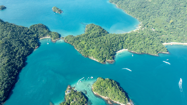 Aerial view of Lagoa Azul featuring turquoise waters lush green islands and small boats navigating the coastal area in Angra dos Reis Rio de Janeiro Brazil.