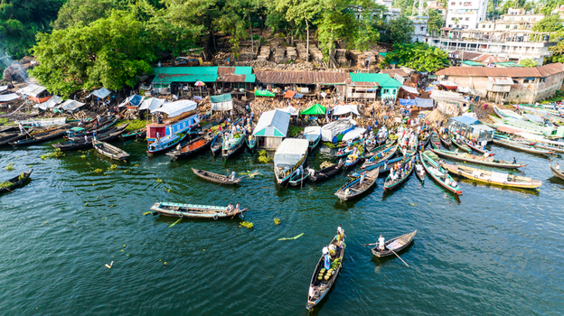 Rangamati Chittagong Division Bangladesh 19 October 2022 Aerial view of a bustling boat market with numerous wooden boats colorful stalls and people navigating the river.