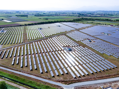 Aerial view of a large solar farm with rows of photovoltaic panels reflecting sunlight under a clear sky in Torrazza Piemonte Piemonte Italy. Aerial view of a large solar farm with rows of photovoltaic panels reflecting sunlight under a clear sky in Torrazza Piemonte Piemonte Italy.
