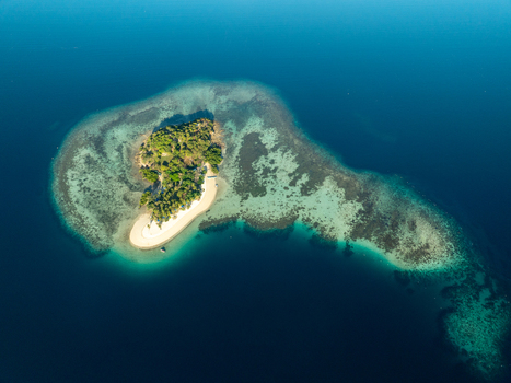 Aerial view of Pass Island surrounded by turquoise coral reefs and deep blue sea in Coron Philippines. Aerial view of Pass Island surrounded by turquoise coral reefs and deep blue sea in Coron Philippines.