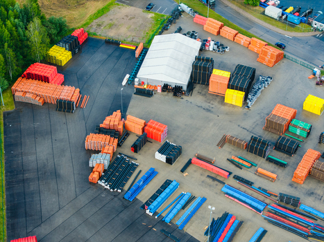 Aerial view of an industrial facility manufacturing polymer pipes with stacks of colorful plastic pipes in orange black yellow and blue arranged in an outdoor storage yard in Jelgava Latvia. Aerial view of an industrial facility manufacturing polymer pipes with stacks of colorful plastic pipes in orange black yellow and blue arranged in an outdoor storage yard in Jelgava Latvia.