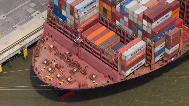 Corringham England United Kingdom 10 July 2026 Aerial view of a large container ship docked at Solent Stevedores London Gateway featuring stacks of colorful shipping containers and deck machinery.