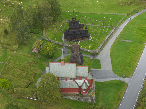 Aerial view of the historic Borgund Stave Church and the red Borgund New Church surrounded by a cemetery and green fields in Borgund Vestland Norway.