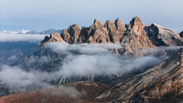 Aerial view of mountain peaks surrounded by swirling clouds and rugged rocky terrain in the Italian Dolomites Tre Cime di Lavaredo Italy. Aerial view of mountain peaks surrounded by swirling clouds and rugged rocky terrain in the Italian Dolomites Tre Cime di Lavaredo Italy.