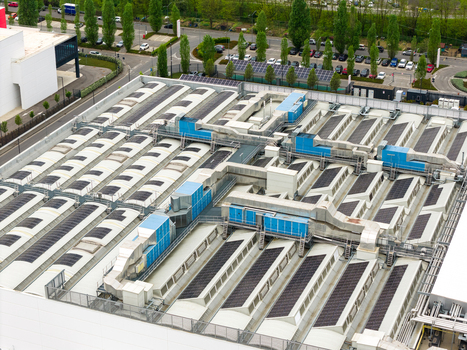 Aerial view of a large industrial rooftop featuring complex ventilation systems HVAC units and skylights San Giovanni Valdarno Tuscany Italy.