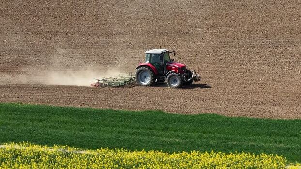 Aerial view of tractor plowing field France.