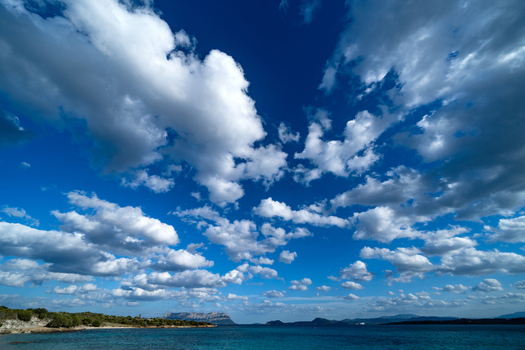 View of Tavolara Island across the turquoise sea with a dramatic cloudy sky Olbia Sardinia Italy. View of Tavolara Island across the turquoise sea with a dramatic cloudy sky Olbia Sardinia Italy.